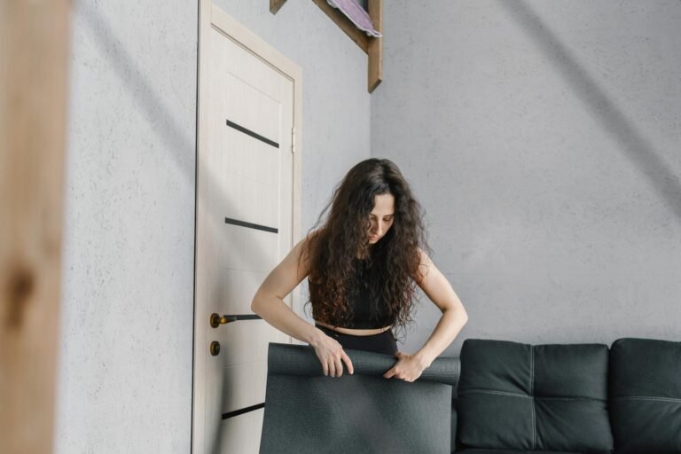 Woman in Black Spaghetti Strap Top and Black Pants Standing Beside White Wooden Door